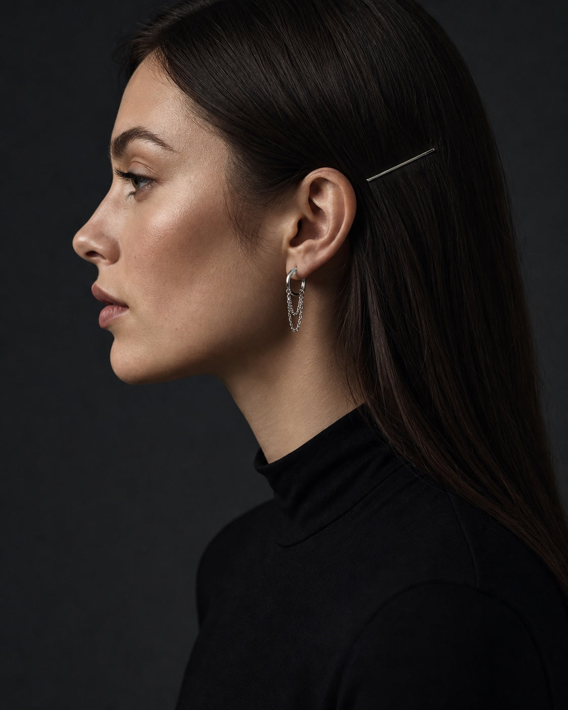 Side profile showing a silver chain earring and metal hair pin